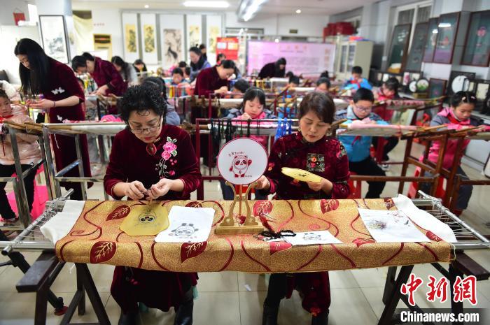江西省級(jí)非遺豫章繡傳承人手把手指導(dǎo)小學(xué)生繡制2022年北京冬奧會(huì)吉祥物“冰墩墩”形象?！∮髟屏?攝