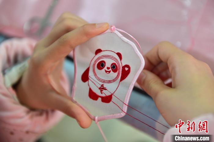 圖為一名小學(xué)生正在繡制2022年北京冬奧會(huì)吉祥物“冰墩墩”形象。　喻云亮 攝