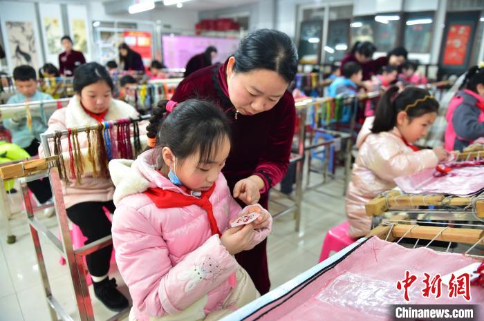 江西省級(jí)非遺豫章繡傳承人手把手指導(dǎo)小學(xué)生繡制2022年北京冬奧會(huì)吉祥物“冰墩墩”形象?！∮髟屏?攝