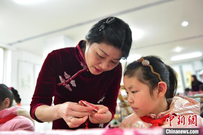 江西省級(jí)非遺豫章繡傳承人手把手指導(dǎo)小學(xué)生繡制2022年北京冬奧會(huì)吉祥物“冰墩墩”形象?！∮髟屏?攝