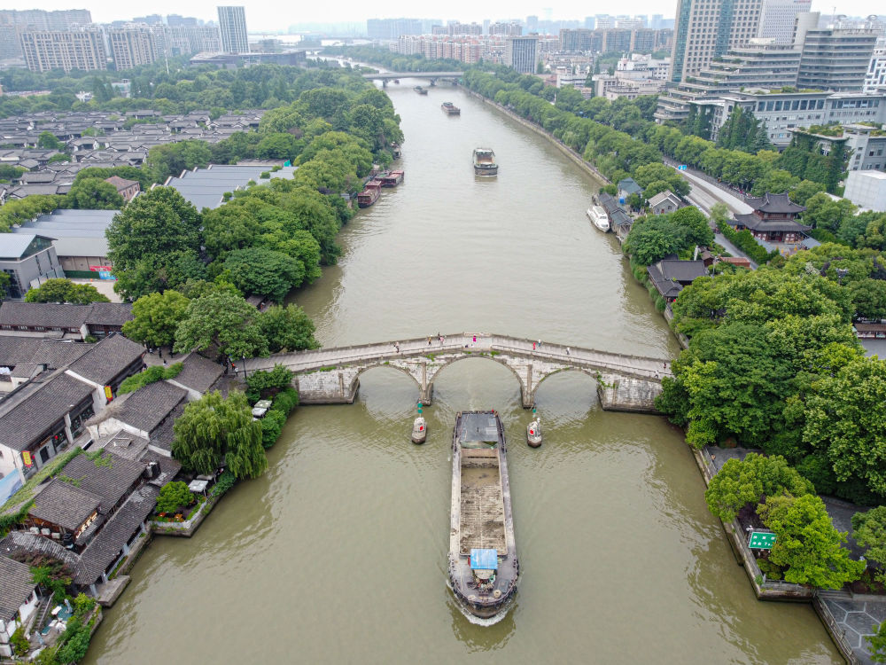5月27日，一艘貨船駛過京杭大運河南端標志建筑杭州拱宸橋。(無人機照片)新華社記者江漢 攝