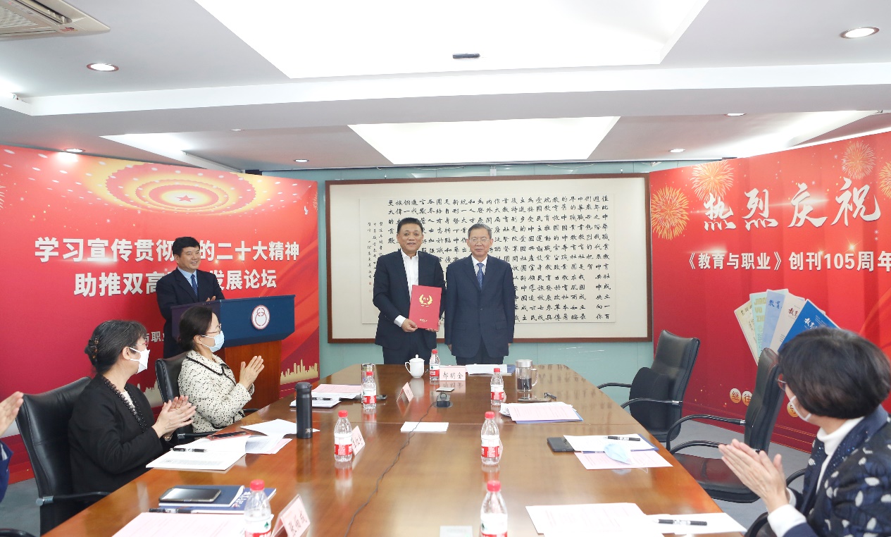 郝明金為《教育與職業(yè)》雜志編委代表陳曉明頒發(fā)聘書。中華職教社供圖