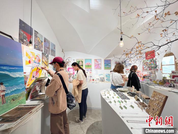 圖為藝術(shù)品商店內(nèi)，顧客挑選插畫作品。　鐘旖 攝