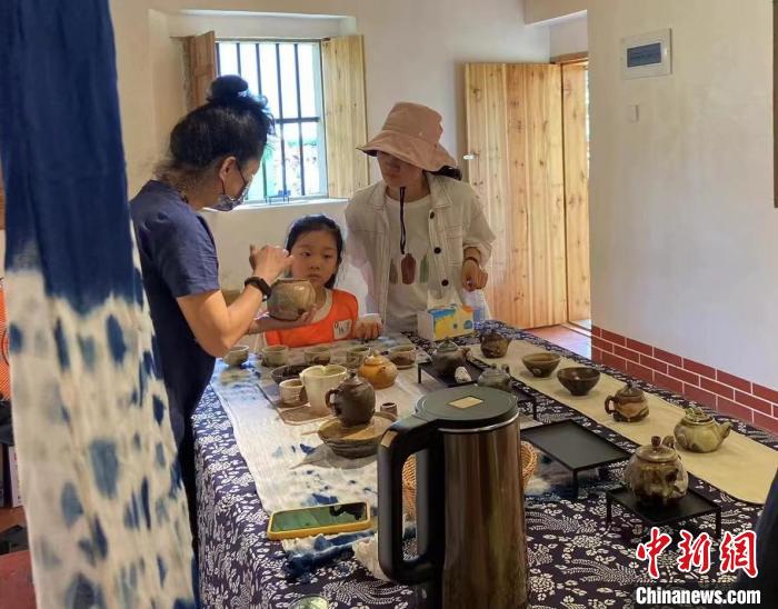 圖為：游客正在咨詢臺(tái)灣柴燒作品?！∪~秋云 攝
