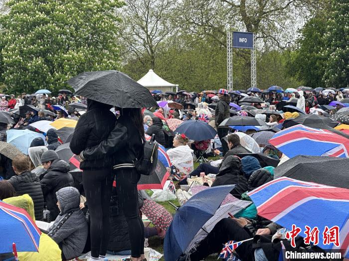 當?shù)貢r間5月6日，英國國王查爾斯三世的加冕儀式舉行。民眾雨中觀看儀式。　歐陽開宇 攝