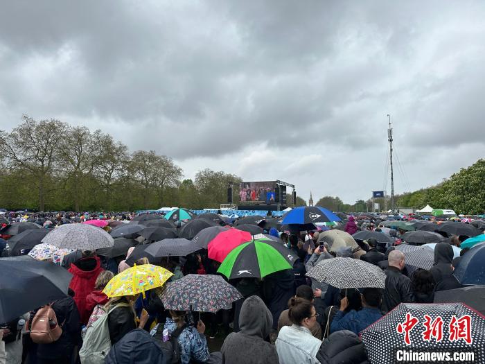 當?shù)貢r間5月6日，英國國王查爾斯三世的加冕儀式舉行。民眾雨中觀看儀式。　歐陽開宇 攝