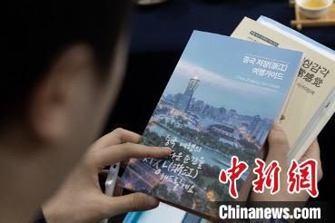 參展觀眾閱讀浙江文旅手冊?！《≌裾?攝