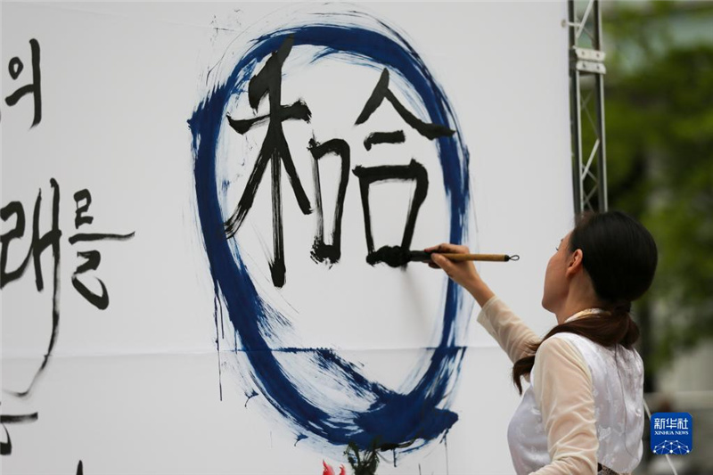 5月30日，在韓國(guó)首爾舉辦的“中日韓合作之日”慶?；顒?dòng)中，表演者進(jìn)行中日韓精神——2023年度漢字“和合”書(shū)法表演。新華社記者 王益亮 攝