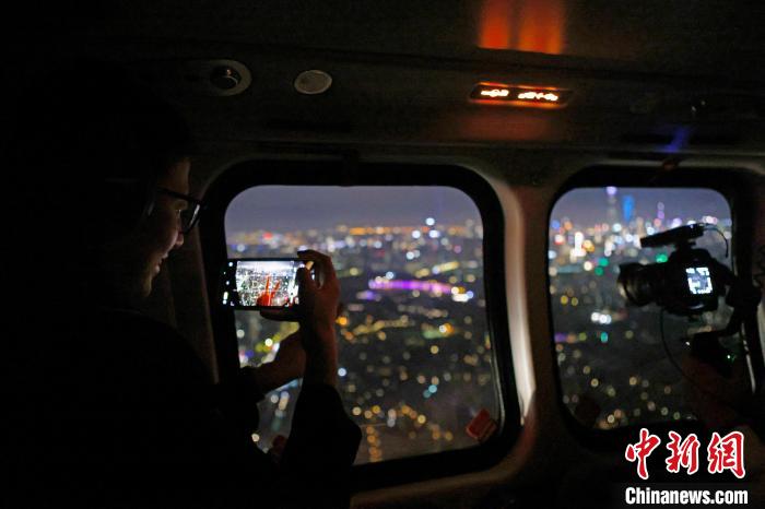 6月3日晚，游客乘坐上海新空直升機(jī)有限公司直升機(jī)開啟鳥瞰黃浦江空中圓夢(mèng)之旅，并用手機(jī)拍攝城市夜景。　殷立勤 攝