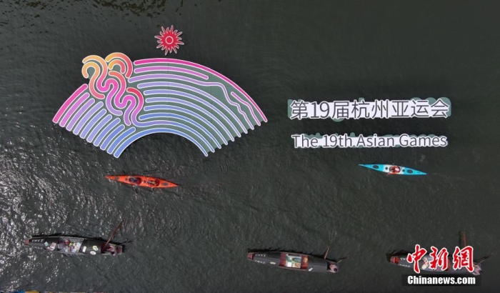資料圖為烏篷船和皮劃艇從杭州亞運會標識前劃過。王剛 攝