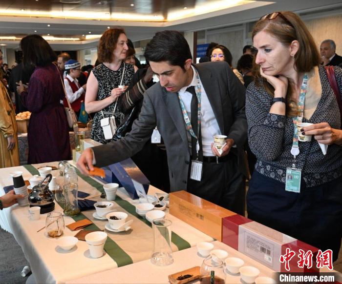 現(xiàn)場觀眾觀看中國展臺(tái)茶藝表演、了解茶文化。　靖樹 攝