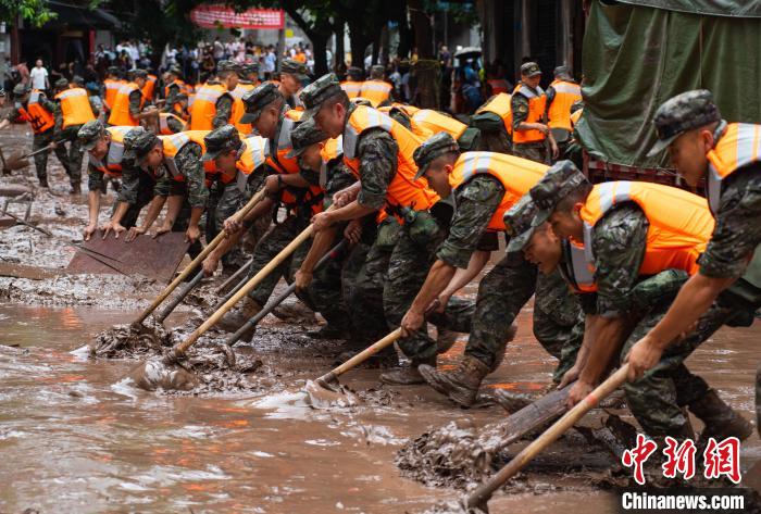 7月4日，萬(wàn)州區(qū)五橋街道，武警官兵清理街道上的淤泥?！∪矫宪?攝