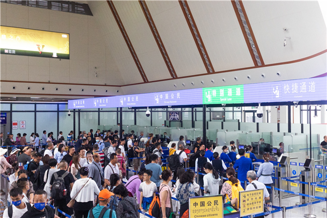 7月22日，乘坐中老鐵路國(guó)際旅客列車的旅客在磨憨邊檢大廳排隊(duì)候檢。衛(wèi)海林 攝