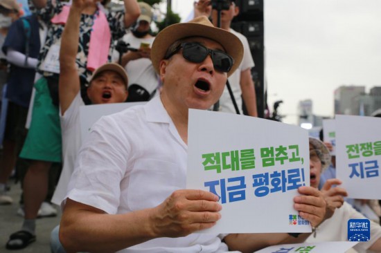 7月22日，在韓國(guó)首爾，人們手舉標(biāo)語(yǔ)參與反戰(zhàn)游行。新華社發(fā)（楊暢 攝）