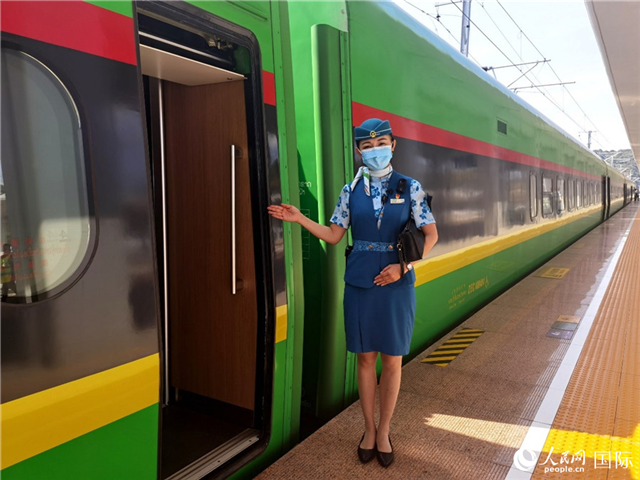 趙瑩靜站在“復興號”國際旅客列車車廂門口歡迎旅客上車。人民網(wǎng) 杜明明攝