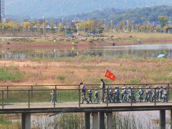 　　10月24日，秋游的幼兒園小朋友在老師帶領(lǐng)下走在清水塘公園里的木橋上。本報(bào)記者 常雯宜攝