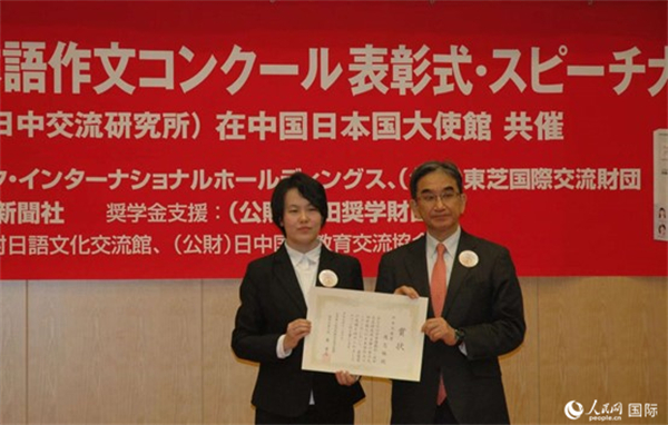 日本駐華大使垂秀夫?yàn)楂@得最優(yōu)秀獎的趙志琳同學(xué)頒獎。人民網(wǎng)記者 陳建軍攝