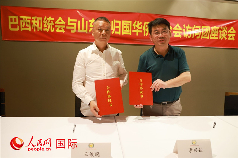 中國(guó)僑聯(lián)副主席、山東省僑聯(lián)主席李興鈺（右）與巴西和統(tǒng)會(huì)會(huì)長(zhǎng)王俊曉簽署合作協(xié)議書。人民網(wǎng)記者 陳海琪攝