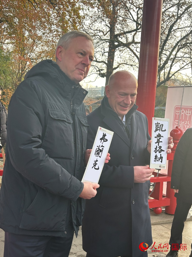 柏林市長韋格納（右）、動物園監(jiān)事會主席布魯克曼（左）手持中國文化中心工作人員現場手書的中文名字。人民網記者 徐馨攝