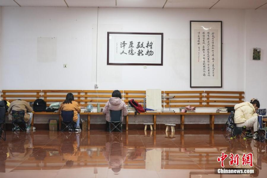 資料圖：幾位考研學(xué)生在南昌大學(xué)教學(xué)樓的公共空間復(fù)習(xí)備考。劉力鑫 攝