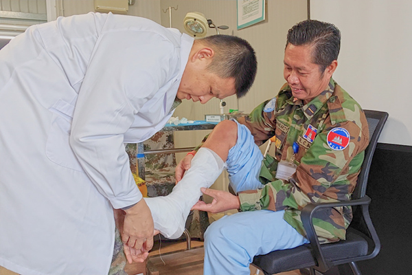 中國第22批赴黎維和醫(yī)療分隊軍醫(yī)為患者打石膏固定患肢。李清竹攝