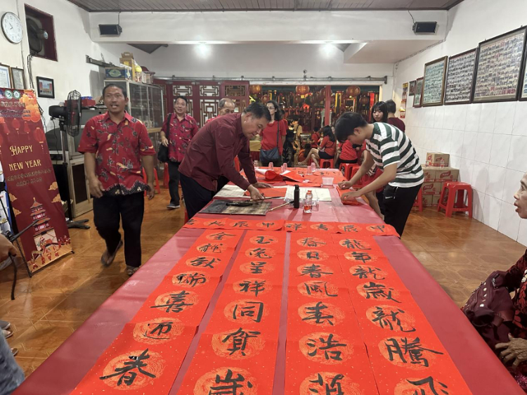 茍皓東為華人朋友現(xiàn)場(chǎng)寫(xiě)春聯(lián)送福字。巴陵康孔子學(xué)院供圖