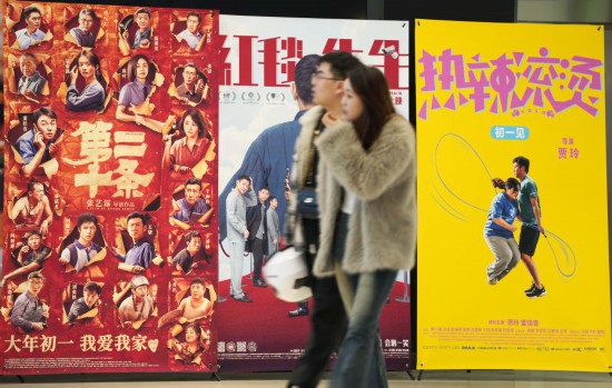 這是2月17日，在沈陽一家影院，觀眾從海報(bào)前經(jīng)過。新華社記者李鋼攝