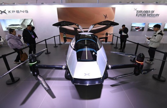 2023年12月1日，在鏈博會(huì)智能汽車鏈展區(qū)小鵬汽車展臺(tái)，參觀者觀看一臺(tái)智能飛行器。新華社記者蔡湘鑫攝