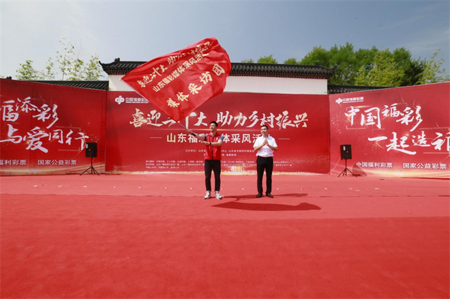 為媒體采風團授旗。 山東省福彩供圖