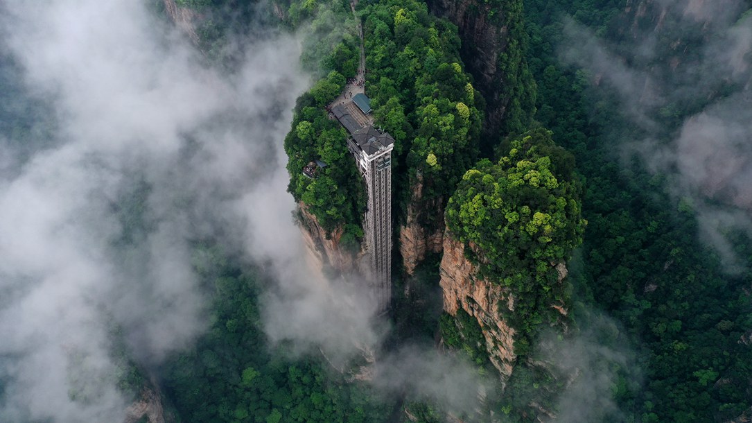 位于張家界武陵源景區(qū)的百龍?zhí)焯蓁偳对谠旗F繚繞的峰林間，雄偉壯觀。吳勇兵攝