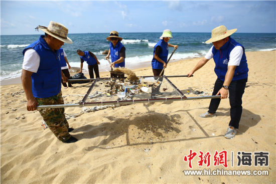 環(huán)保志愿者用篩網(wǎng)“淘”出海灘上的垃圾。