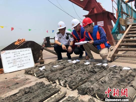 圖為勘察設(shè)計(jì)人員與海事局工作人員查看巖芯情況?！∥赫?攝