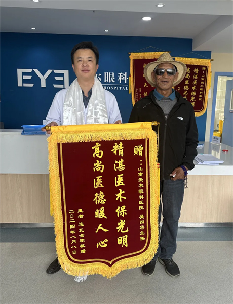 達(dá)瓦老人向吳四華（左）贈送錦旗。受訪者供圖
