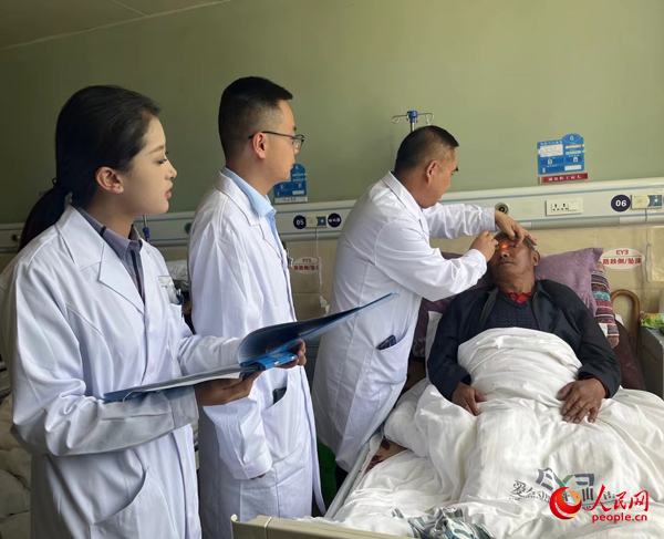 董光明（左三）帶領(lǐng)醫(yī)生對患者進(jìn)行術(shù)前檢查。人民網(wǎng)記者 杜燕飛攝