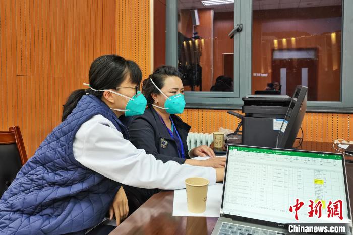 8月9日，楊蘇喬(左)在拉薩方艙醫(yī)院指揮部讀取艙內患者胸部CT?！∈茉L者供圖
