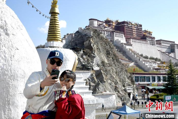 4月17日，游客身著藏式元素服裝在拉薩布達(dá)拉宮觀景臺(tái)拍照留念。　李林 攝