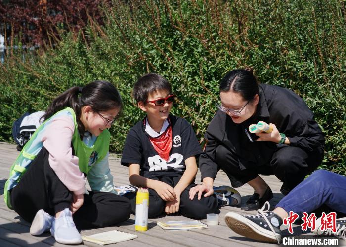 圖為小朋友在青海西寧湟水國家濕地公園內(nèi)認識植物并進行繪畫。　馬銘言 攝