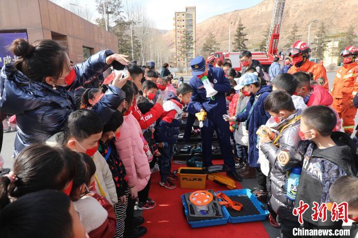 圖為小朋友們聽消防員講解消防器材。　楊龍建 攝