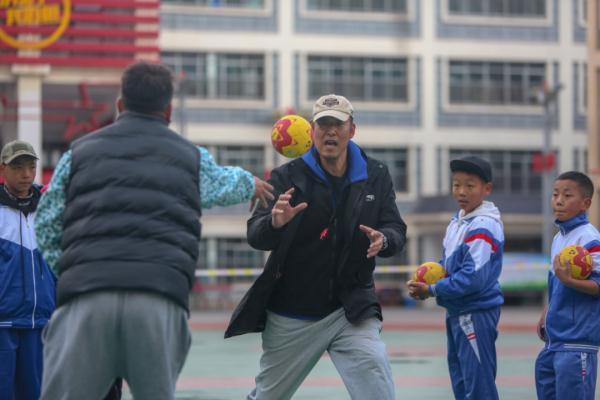 在高原上教孩子們打手球，“慢慢兒來，甭著急！”
