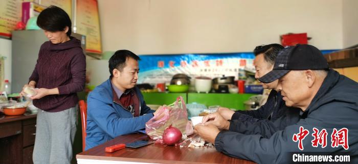 圖為扶貧路上“臨時(shí)一家人”準(zhǔn)備午餐?！∥航ㄜ?攝