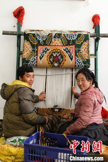 圖為1月15日，在日喀則市謝瑪氆氌農(nóng)村合作社，拉孜村一對(duì)夫婦在編織卡墊(資料圖)。　趙朗 攝