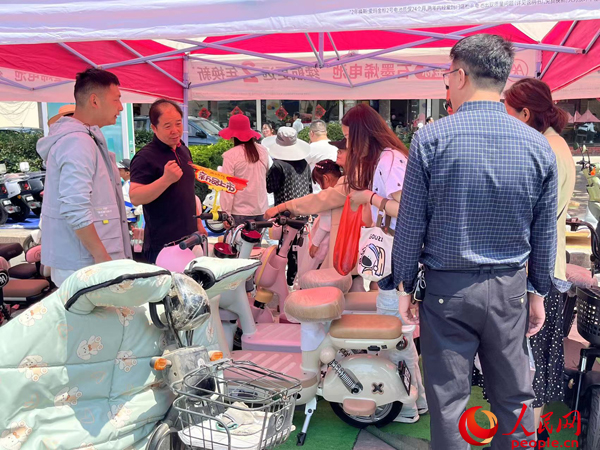 某電動自行車品牌工作人員向消費者介紹以舊換新相關(guān)情況。人民網(wǎng)記者 杜燕飛攝