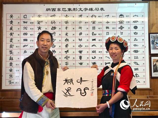 人民網(wǎng)“行進中國”云南調(diào)研采訪團走進麗江，和閏元現(xiàn)場用東巴文寫下“行進中國”。人民網(wǎng)記者 符皓攝