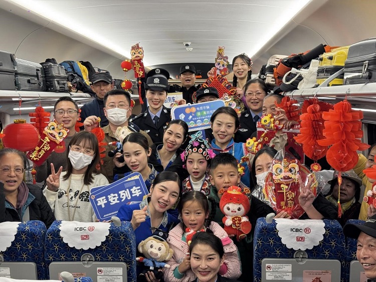 春節(jié)期間，在中老鐵路磨萬（磨丁—萬象）段，鐵路客運員工與乘客合影留念。李加勇攝