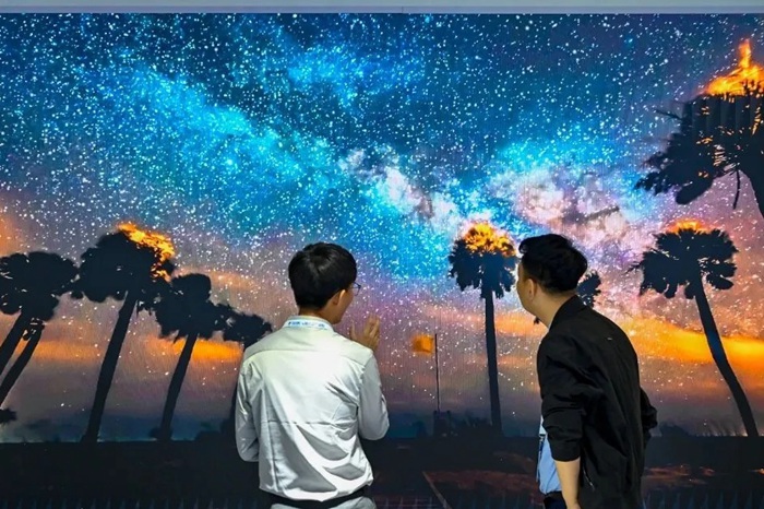 長春光博會希達電子展區(qū)，一位工作人員正在給一位觀眾講解。（長春新區(qū)供圖）