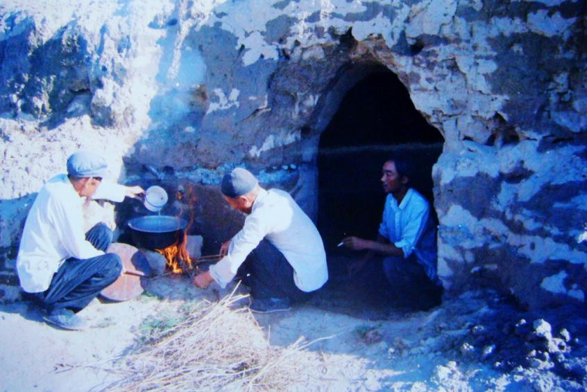 1983年，“六老漢”一代治沙人在“地窩子”生活做飯。新華社發(fā)（八步沙林場供圖）