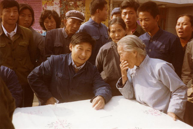 1983年，時(shí)任河北正定縣委書記的習(xí)近平（前排居中），臨時(shí)在大街上擺桌子聽取老百姓意見。
