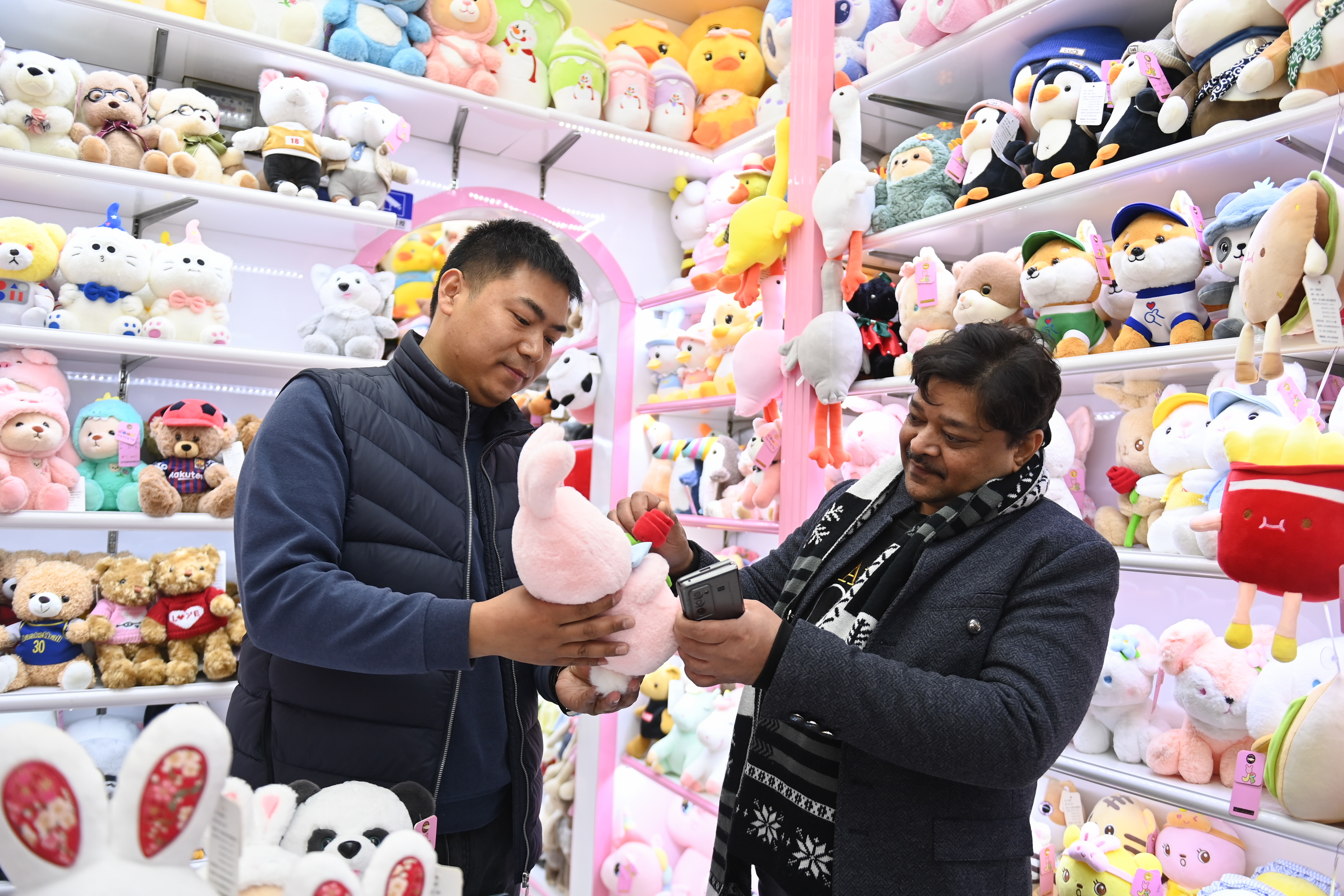 2023年2月2日，來(lái)自印度的客商（右）在義烏國(guó)際商貿(mào)城的一家玩具店鋪內(nèi)選購(gòu)。