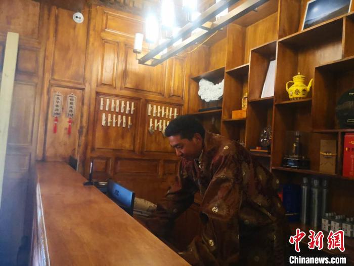 圖為桑杰才讓用電腦處理財(cái)務(wù)?！∈缝o靜 攝