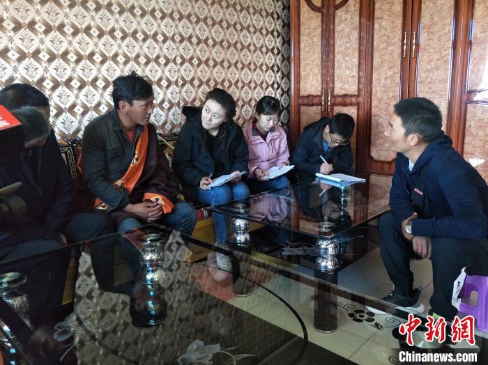圖為調(diào)查組工作人員正在入戶調(diào)查?！∑钤鲚?攝